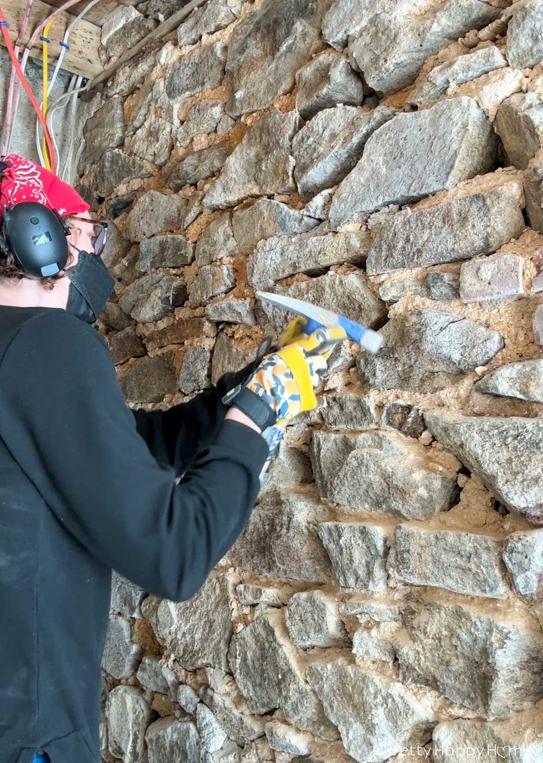 carriage house gym expansion stone foundation repointing removing and demoing old lime mortar off a fieldstone foundation wall using a hand chisel and specialty hammer