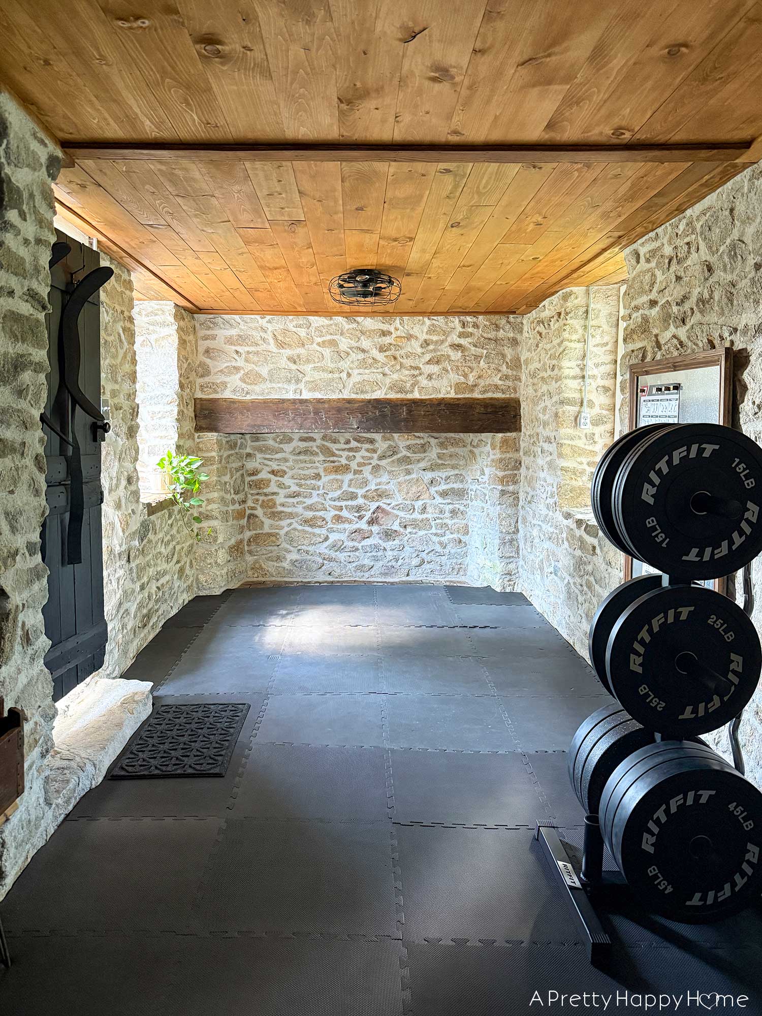 Converting a Door Into a Window In a Stone Building inside of a stone building with a home gym