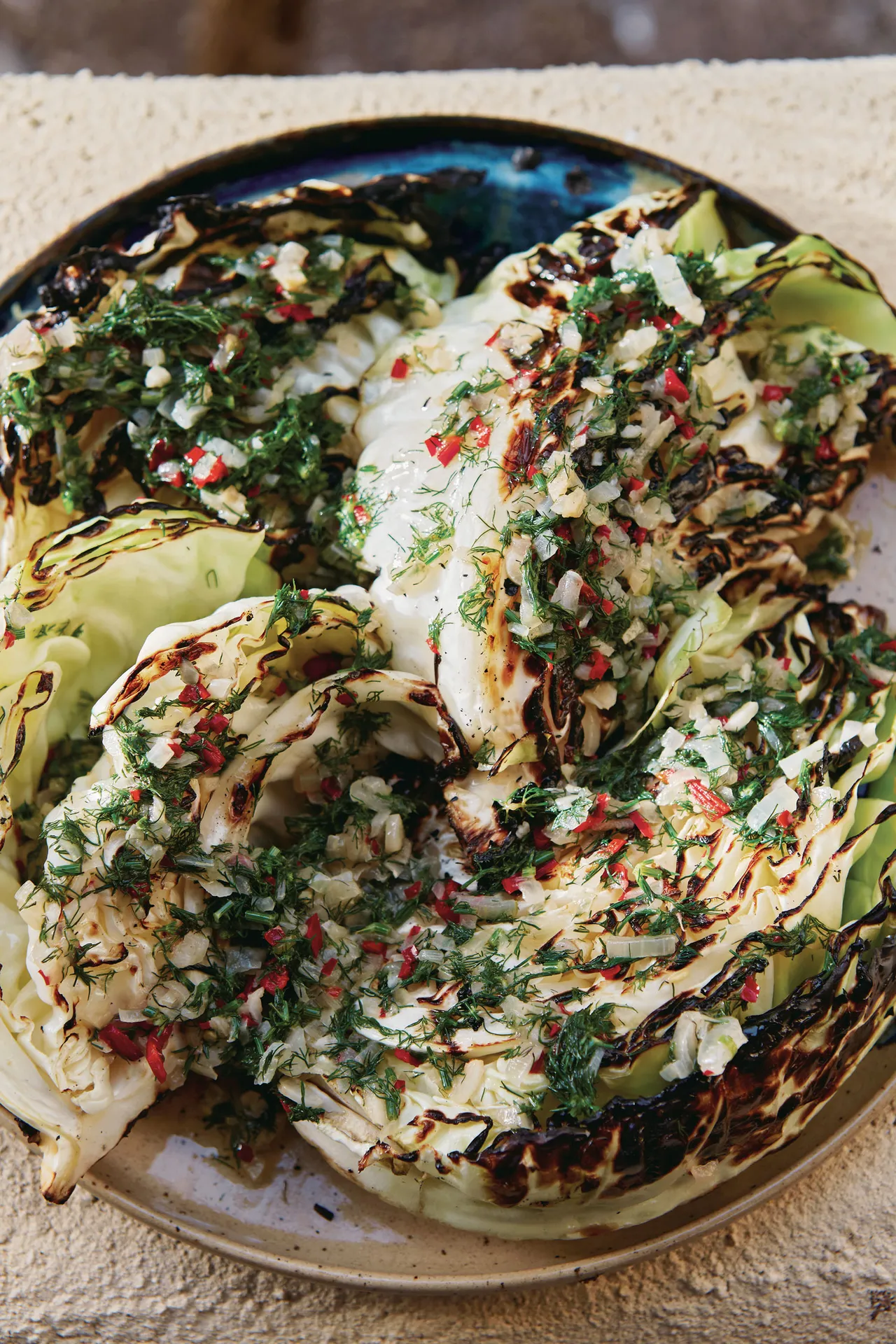 grilled green cabbage, lightly charred with a drizzle of chili garlic butter by Sarit Packer and Itamar Srulovich